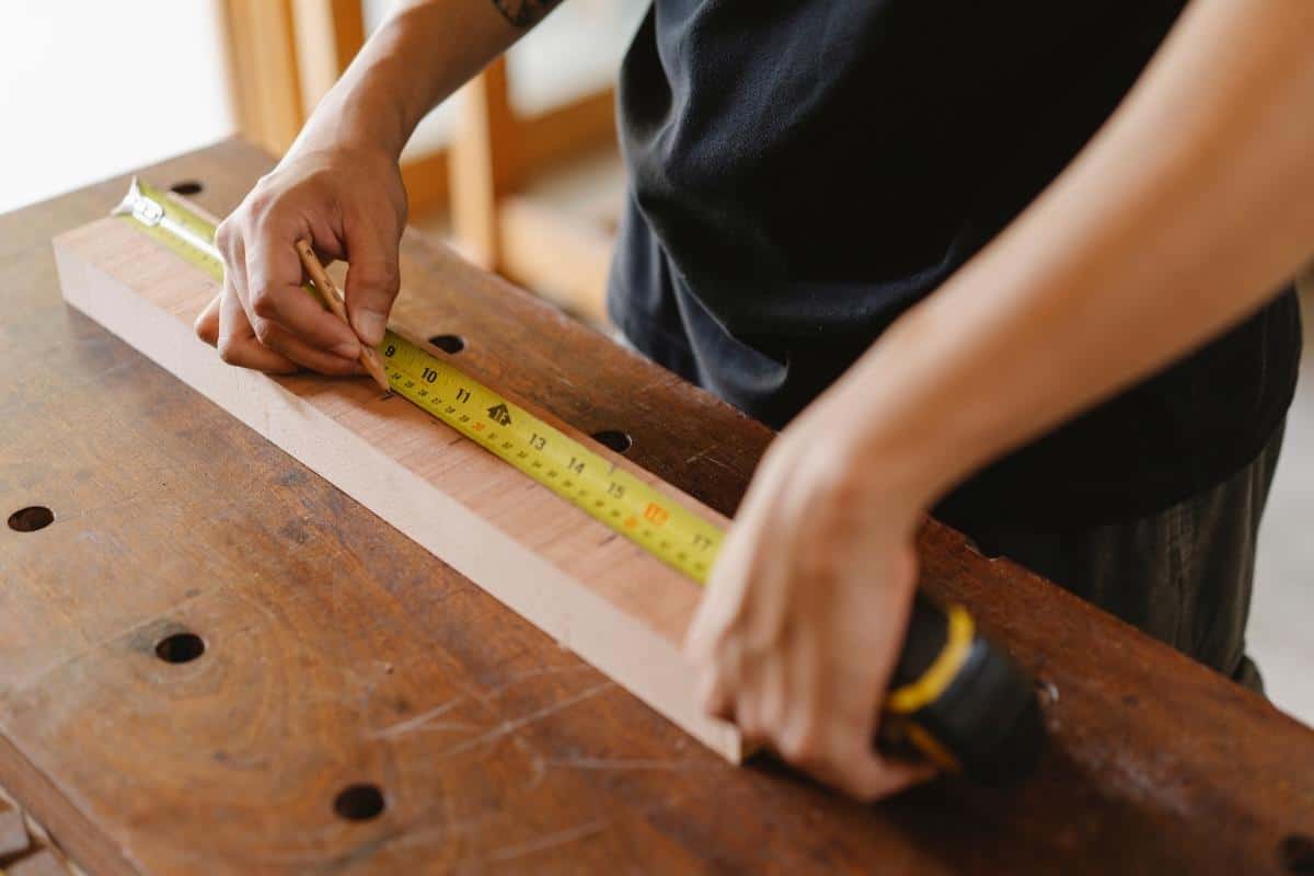 Measuring a timber board with a tape measure